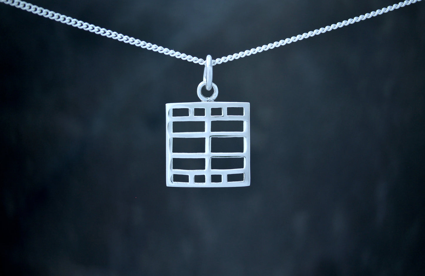 A 925 sterling silver pendant with a geometric windows design, based on the art of Charles Rennie Mackintosh.
