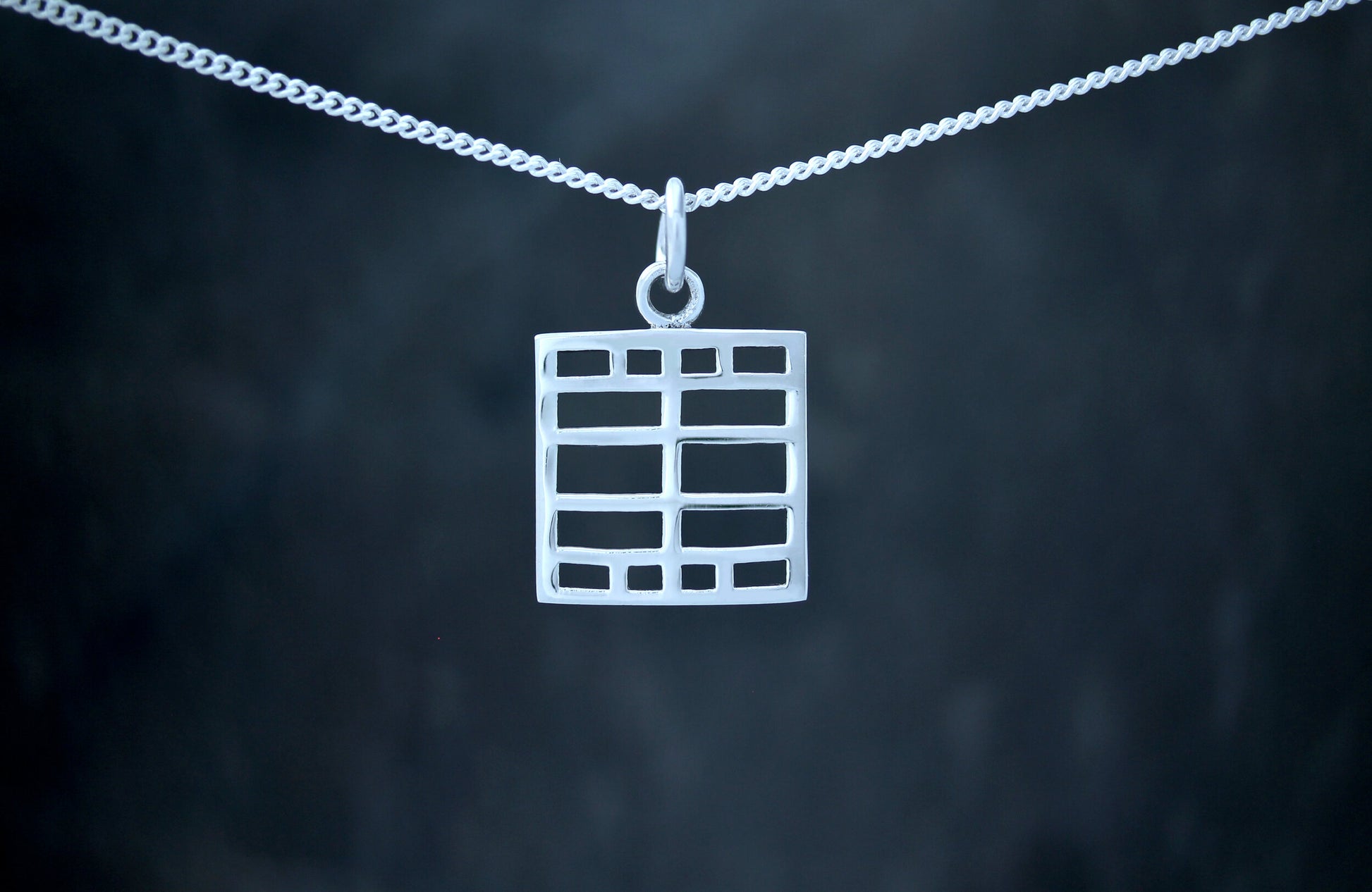 A 925 sterling silver pendant with a geometric windows design, based on the art of Charles Rennie Mackintosh.